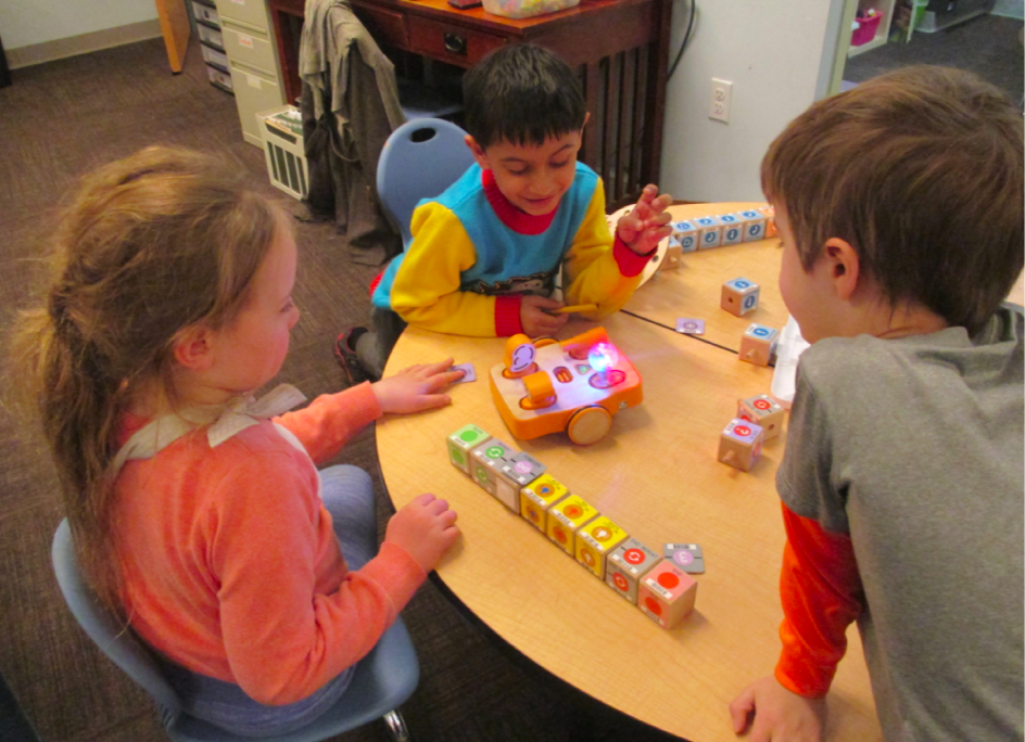 Three kids collaborating with KIBO AI technology
